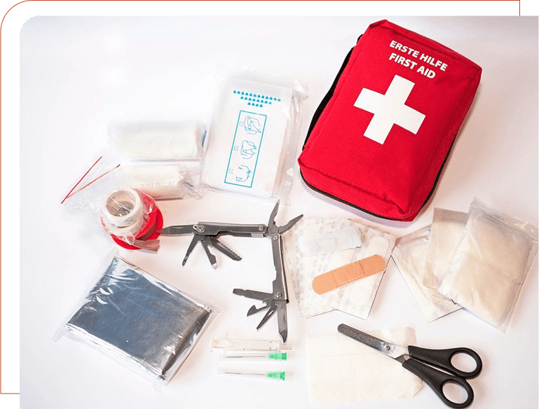 A red and white first aid kit with scissors, bandaids, and other items.