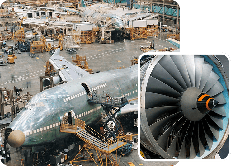 A large airplane is parked in an industrial area.