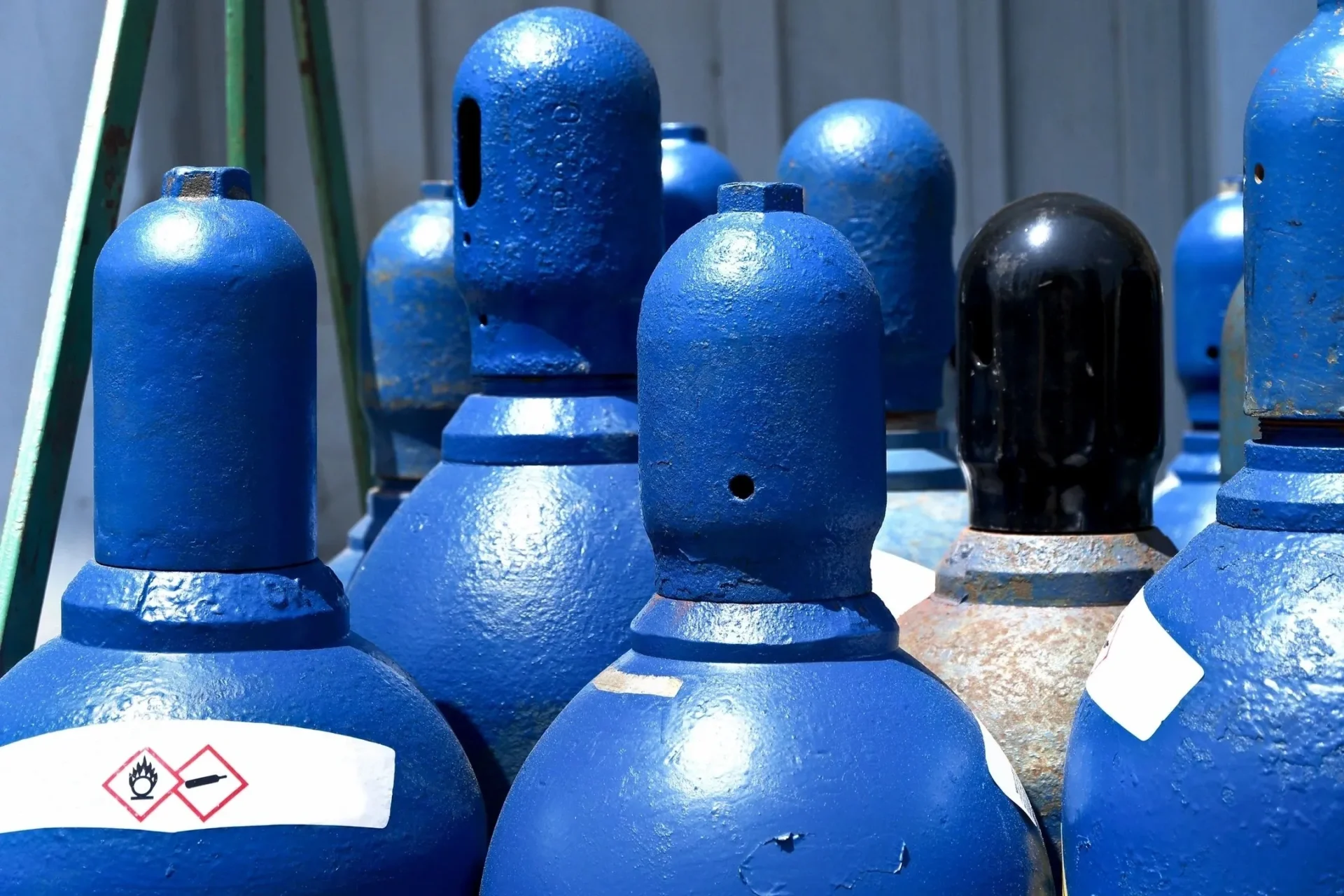 A group of blue gas bottles sitting next to each other.