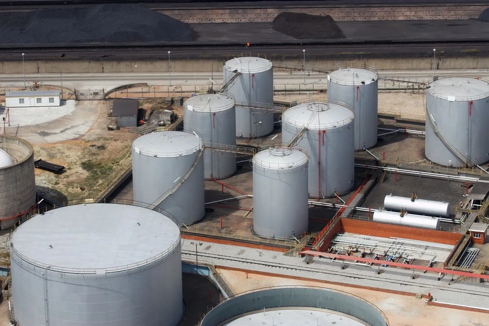 A group of large white tanks sitting on top of concrete.