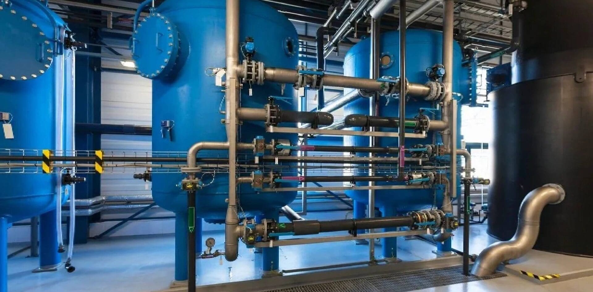 A large blue tank sitting next to pipes.