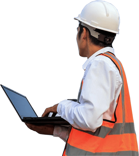 A man in an orange vest and hard hat using a laptop.